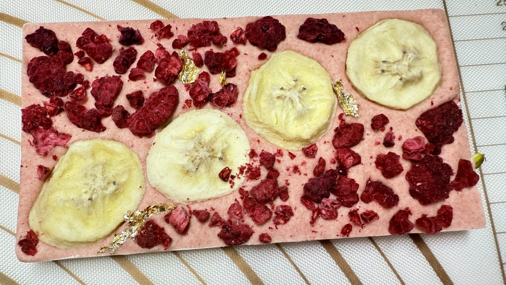 White chocolate mixed Strawberry powder & Bananas Raspberry & Gold on top 100g.